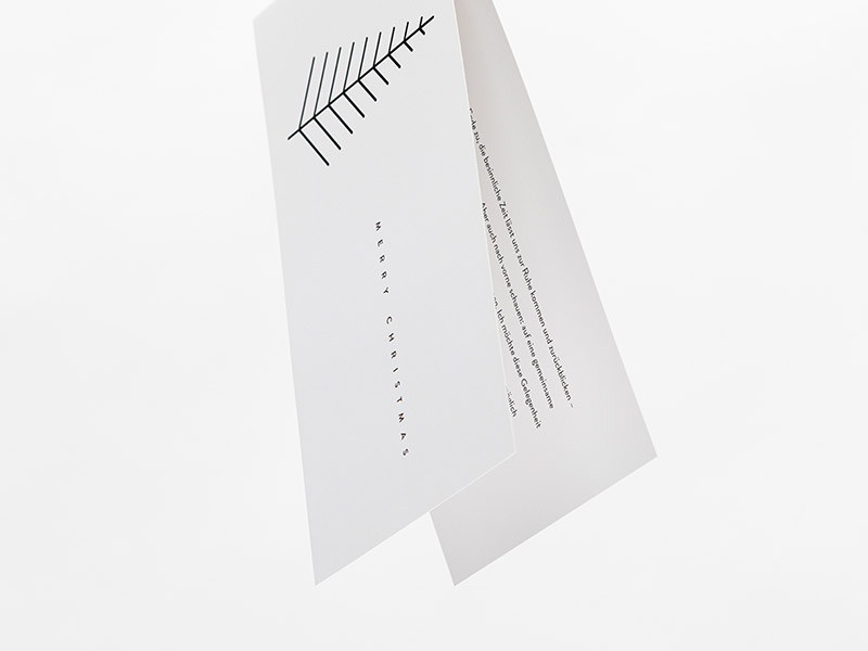 Eine schräg gestellte, leicht aufgeklappte Grußkarte im schmalen Querformat und der Aufschrift Einladung.