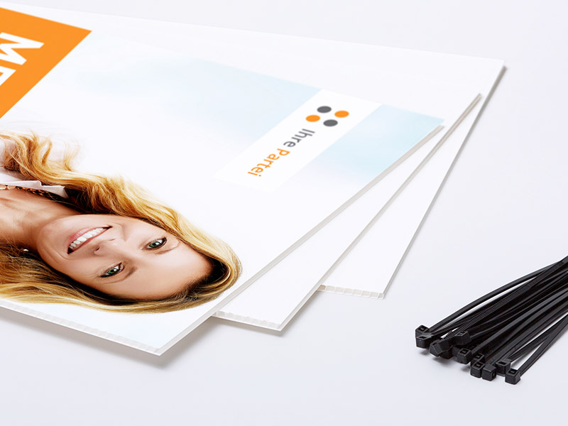 Die Abbildung zeigt einen Stapel von 3 aufgefächerten Hohlkammerplakaten. Daneben liegen mehrere Kabelbinder zur Befestigung.